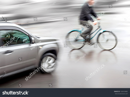 stock-photo-dangerous-city-traffic-situation-with-a-cyclist-and-cars-intentional-motion-blur-162618482